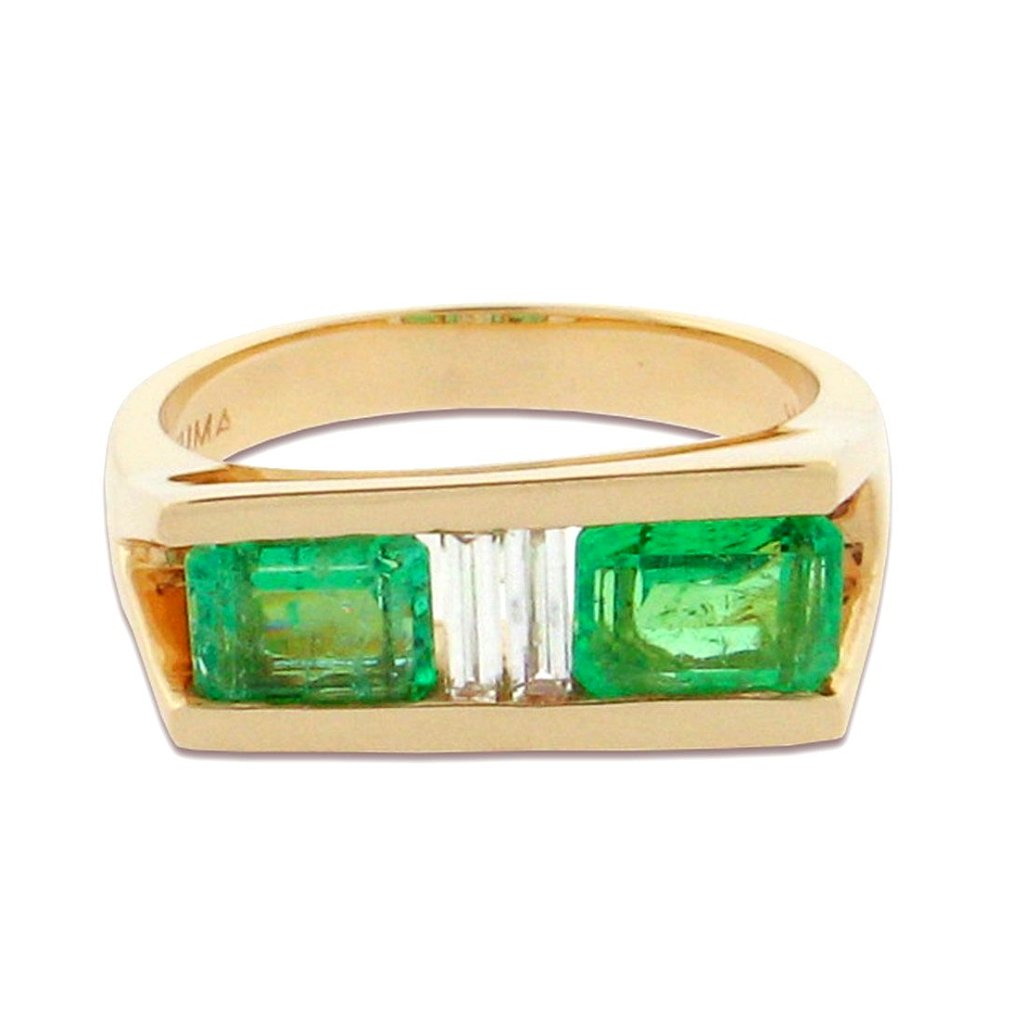 two emerald cut emeralds with baguette cut diamonds in between, set in a 14 k yellow gold ring