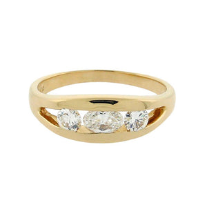 oval diamond in center with two round diamonds on the side set in a 14 k yellow gold ring